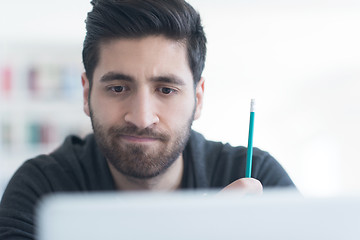 Image showing student in school library using laptop for research