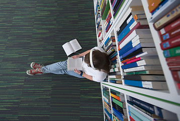 Image showing female student study in library, using tablet and searching for 