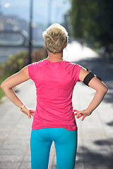 Image showing jogging woman setting phone before jogging