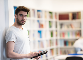 Image showing student in school library using tablet for research