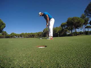 Image showing golf player hitting shot at sunny day