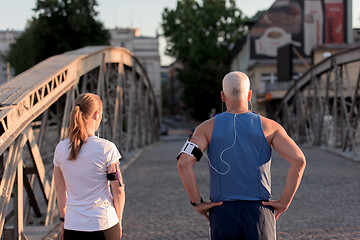 Image showing jogging couple planning running route  and setting music