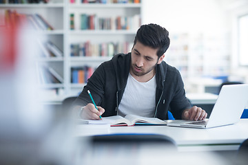 Image showing student in school library using laptop for research