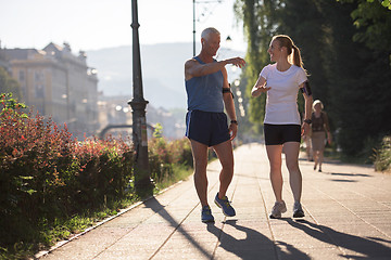 Image showing jogging couple planning running route  and setting music