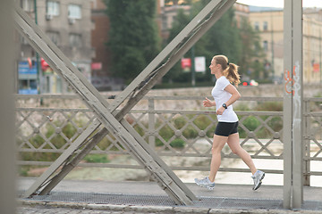 Image showing sporty woman running  on sidewalk