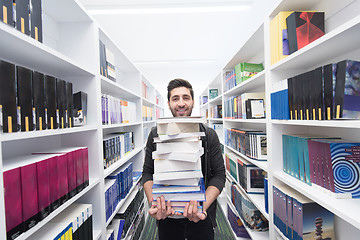 Image showing Student holding lot of books in school library