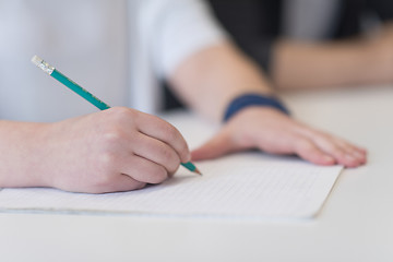 Image showing male student taking notes in classroom