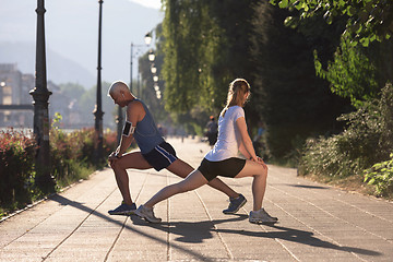 Image showing couple warming up and stretching before jogging