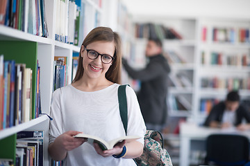 Image showing portrait of famale student reading book in library