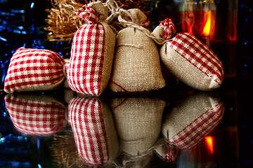 Image showing Christmas decorations, gifts, candle and reflections on the glass