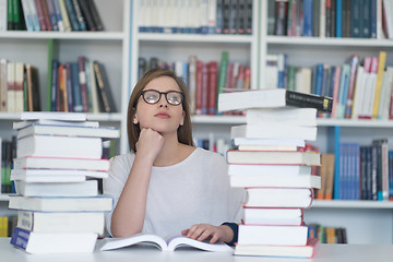 Image showing female student study in library, using tablet and searching for 