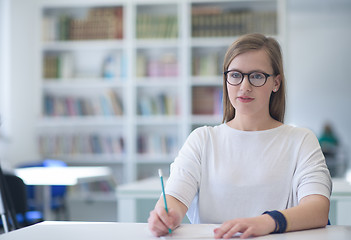 Image showing famale student reading book in library