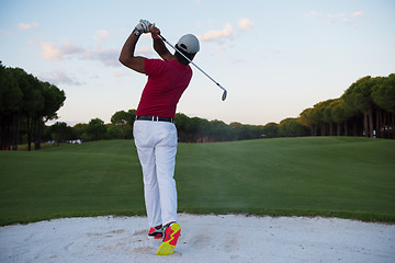 Image showing golfer hitting a sand bunker shot on sunset