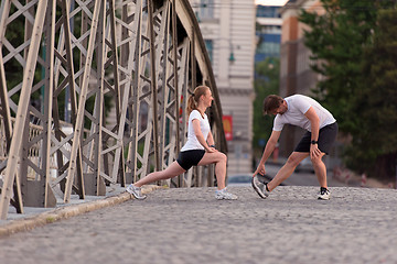 Image showing couple warming up and stretching before jogging