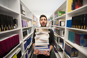 Image showing Student holding lot of books in school library