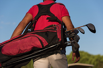 Image showing close up of golfers back while   walking and carrying golf  bag