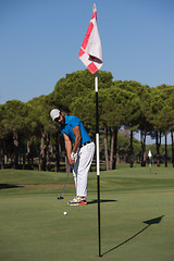 Image showing golf player hitting shot at sunny day