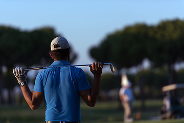 Image showing golfer from back at course looking to hole in distance