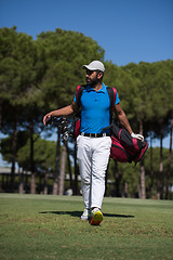 Image showing golf player walking and carrying bag