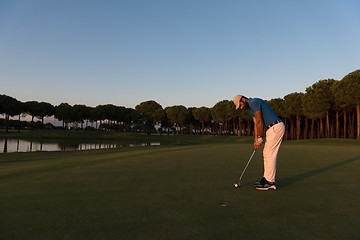 Image showing golfer  hitting shot at golf course