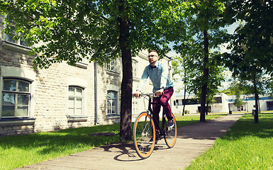 Image showing happy young hipster man riding fixed gear bike