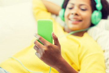 Image showing happy african woman with smartphone and headphones