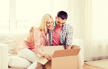 Image showing happy couple with cardboard box or parcel at home