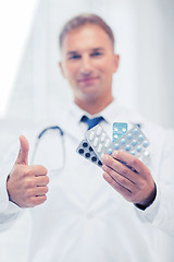 Image showing male doctor with packs of pills