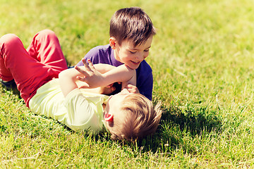 Image showing happy little boys fighting for fun on grass