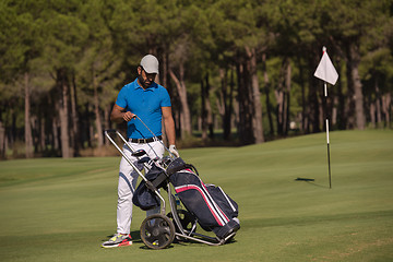 Image showing golf player walking with wheel bag