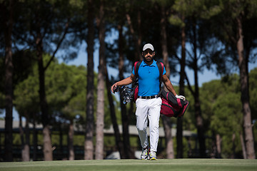 Image showing golf player walking and carrying bag