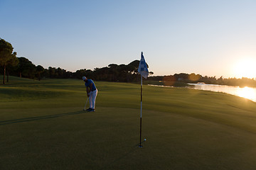 Image showing golfer hitting ball to hole