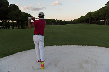 Image showing golfer hitting a sand bunker shot on sunset