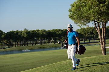 Image showing golf player walking and carrying bag