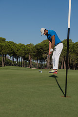 Image showing golf player hitting shot at sunny day