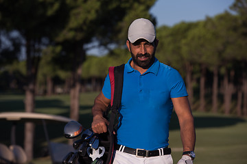 Image showing golfer  walking and carrying golf  bag