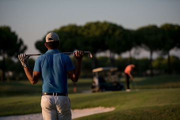 Image showing golfer from back at course looking to hole in distance