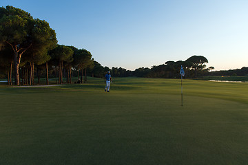 Image showing golfer hitting ball to hole