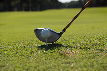 Image showing golf player placing ball on tee