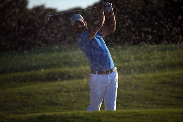 Image showing golfer hitting a sand bunker shot on sunset