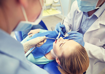 Image showing close up of dentist treating female patient teeth
