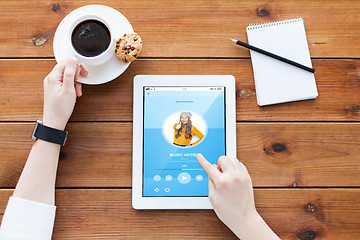 Image showing close up of woman with tablet pc on wooden table