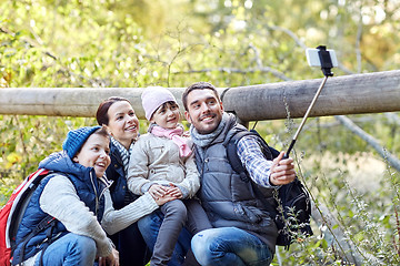 Image showing happy family with smartphone selfie stick in woods