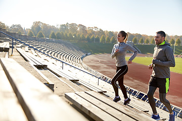 Image showing happy couple running upstairs on stadium