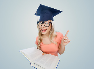 Image showing student woman in mortarboard with encyclopedia