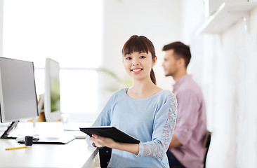 Image showing happy creative female office worker with tablet pc