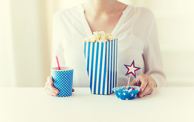 Image showing woman eating popcorn with drink and candies