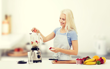 Image showing smiling woman with blender preparing shake