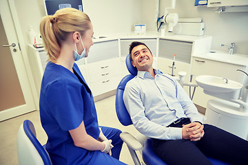 Image showing happy female dentist with man patient at clinic