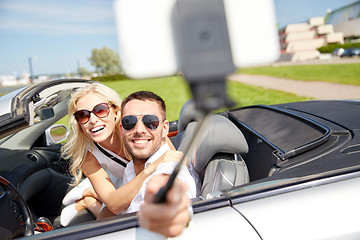 Image showing happy couple in car taking selfie with smartphone